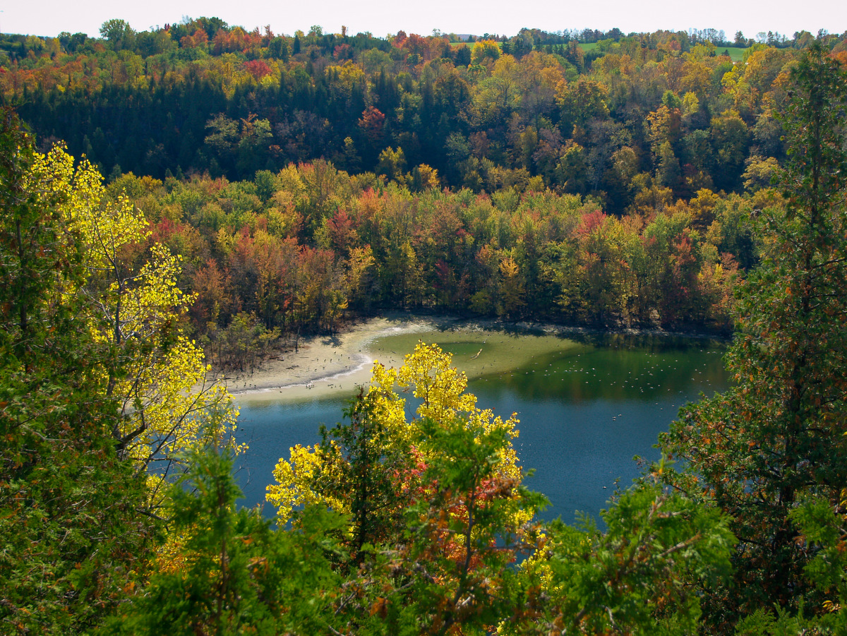 A view of a blue lake and surrounding trees in fall